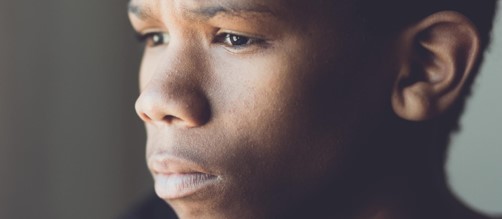 Photo of a black boy looking concerned or sad.