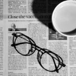 Photo of a newspaper with glasses and a mug