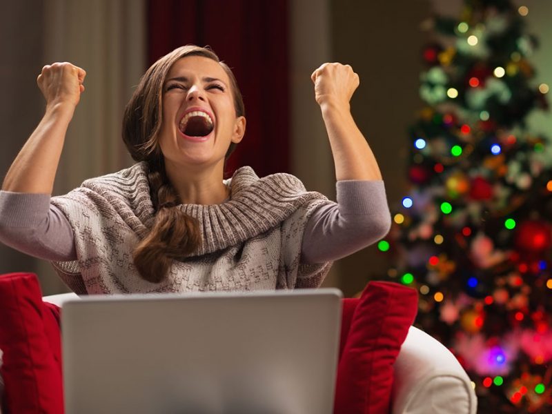 a white woman siting in living area with her laptop