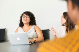 A photo of female office workers at a conference table.